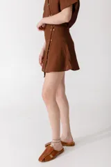 Minifalda color ladrillo con rayas verticales finas y botones dorados en el lateral.