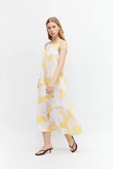 Maxi vestido amarillo con estampa floral, de tirantes y corte suelto.