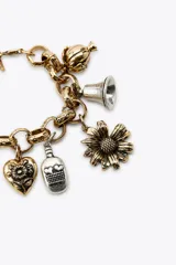 Pulsera dorada con eslabones metálicos y colgantes de diferentes charms plateados y dorados.