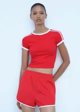 Short deportivo rojo con cintura elástica, terminaciones en contraste color blanco y dos bolsillos laterales.