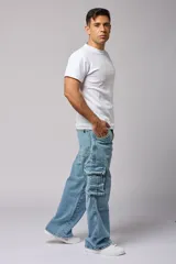Pantalón jean celeste de corte amplio, estilo cargo, con bolsillos laterales con fuelle y solapa.