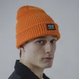 Gorro de lana blanco con etiqueta negra con el logo de la marca Pulau.