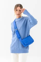 Bandolera azul acolchada con correa ancha ajustable con hebilla metálica.