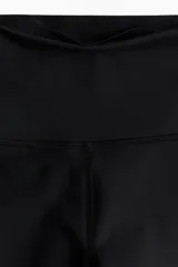 Calzas deportivas negras de tejido funcional DryMove™ que ayuda a absorber el sudor. Diseño con cintura ancha de tiro alto y bolsillo oculto en la parte trasera.