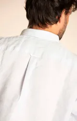 Camisa de manga larga color durazno, confeccionada en lino orgánico, con cuello italiano, cierre con botones y bolsillo en el pecho con logo bordado al tono.