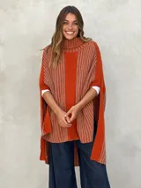 Poncho marrón de tejido de punto con cuello alto y diseño asimétrico.