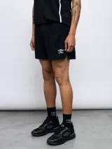 Short deportivo negro de poliéster y elastano, con logo de Umbro estampado en blanco en la pierna izquierda.