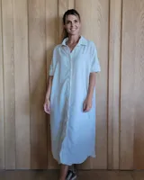 Vestido tipo túnica de manga corta con cuello camisero y cierre frontal con botones. Diseño a rayas verticales en tonos verde y blanco.