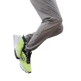 Pantalón de entrenamiento gris con puños, bolsillos laterales con cierre y logo de Topper estampado en verde.