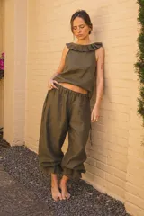 Pantalón de lino color verde oliva, de corte amplio con frunces elásticos en el ruedo.