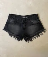 Short de jean negro con terminaciones desflecadas.