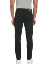 Pantalón de gabardina negro de corte slim taper fit, con cinco bolsillos, cierre con botón y remaches metálicos.
