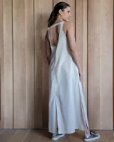 Vestido largo azul melange de corte imperio, con escote en V y breteles finos. Presenta una abertura lateral en la falda.