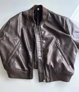 Campera bomber marrón de cuero ecológico con cierre frontal y bolsillos laterales con cierre.