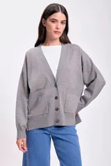 Cárdigan de punto color gris con escote en V, cierre con botones y bolsillos frontales.