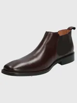 Bota Chelsea de cuero negro con elásticos laterales y suela plana.
