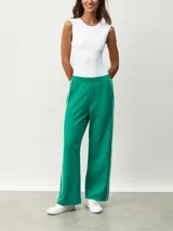 Pantalón blanco de corte ancho con una fina línea negra vertical en los laterales.