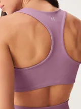 Top deportivo color malva, de corte cuadrado y tirantes anchos, diseñado para actividades físicas.