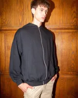 Hoodie negro con cierre frontal completo y diseño de corte holgado.
