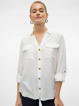 Camisa blanca de mangas largas con vuelta, cuello clásico, cierre frontal con botones y dos bolsillos con solapa en el pecho.