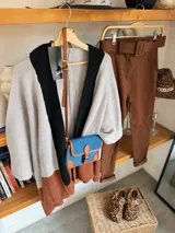 Pantalón de vestir marrón con cinturón de hebilla rectangular, corte ajustado y bolsillos laterales.