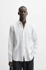 Camisa celeste de lino, de corte recto, manga larga y cuello clásico.