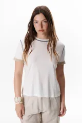 Remera blanca de manga corta con cuello redondo y detalle de costuras en contraste en cuello y mangas.
