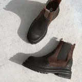 Botas Chelsea negras de cuero con elásticos laterales, tirador trasero y suela track.