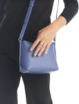 Cartera bandolera Tahari modelo Cooper, color azul, confeccionada en ecocuero con textura granulada. Cuenta con asa larga regulable, compartimento principal con cierre, bolsillos internos y un monedero extra con cierre.