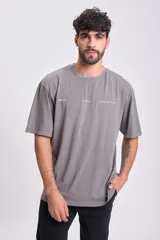 Camiseta manga corta oversize color gris oscuro con estampa trasera con la palabra 'Pixel' en blanco y diseño geométrico.