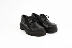 Mocasín negro de cuero con plataforma track y cordones.