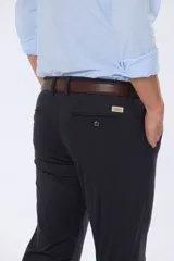 Pantalón de vestir azul marino, de corte recto, con bolsillos laterales y traseros. Se ajusta a la cintura con cinturón de cuero marrón.