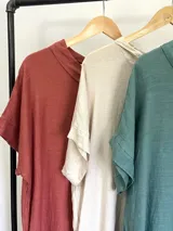 Vestido largo color ladrillo, de lino, corte amplio, mangas cortas, cuello bote y bolsillos laterales.