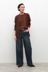 Ruana de tejido de punto color marrón chocolate, con cuello en V y diseño abierto, sin mangas.