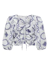 Top corto blanco con estampado de flores azules, cuello cuadrado y mangas cortas abullonadas.