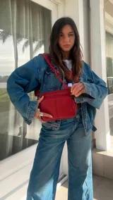 Bandolera color gris oscuro con doble bolsillo principal, un bolsillo frontal y uno trasero, todos con cierre. Incluye correa ajustable y logo de la marca "Lincoln's" grabado en el frente.