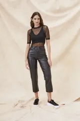 Polera negra de manga corta con cuello alto, confeccionada en tul transparente.