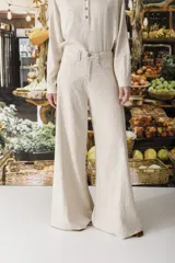 Pantalón de lino color crudo con finas rayas verticales negras, corte wide leg y tiro alto.