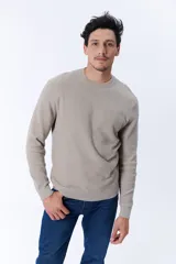 Buzo de punto color beige con textura acanalada y cuello redondo.