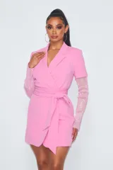 Vestido corto tipo blazer color rosa, con escote cruzado, cinturón y mangas largas de strass.