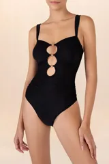 Traje de baño entero negro con escote bandeau, breteles ajustables, cortes circulares con cuentas al centro y recogidos laterales.