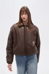 Campera estilo bomber de eco-cuero color marrón oscuro, con cuello camisero, cierre frontal y puños y cintura ajustados.
