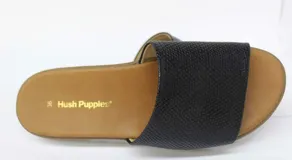 Sandalia con capellada de cuero negro con textura de piel de serpiente. Suela blanca con base marrón.