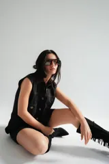 Vestido corto de jean gris con botones frontales, sin mangas, con cuello camisero y bolsillos en el pecho.