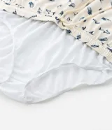 Bermuda de baño para hombre, color crema, con estampado repetitivo de peces azules. Presenta cintura elástica con cordón de ajuste y forro interior de malla.