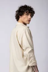 Camisa color arena de lino, manga larga, con cuello clásico y corte holgado.