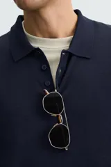 Polo de manga larga color negro, tejido en hilatura con mezcla de algodón y seda, de corte regular fit, con cuello solapa y cierre frontal de botonadura.
