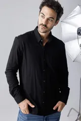 Camisa negra de piqué, corte clásico, con cuello abotonado y bolsillo en el pecho.