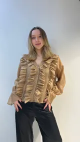 Camisa negra de gasa con escote en V, doble volado frontal, mangas largas abullonadas con puños elásticos y cierre frontal con botones.