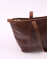 Bolso tote de cuero color suela con textura tipo cocodrilo, doble asa de hombro y cierre superior. Incluye bolsillo interior y llavero.